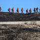 Inmate firefighters march past an American flag, while led by a fire captain, as they work to put out hot spots from the Tick Fire on October 25, 2019 in Canyon Country, California.
